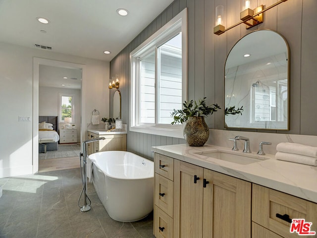 bathroom featuring a bath, tile floors, and vanity