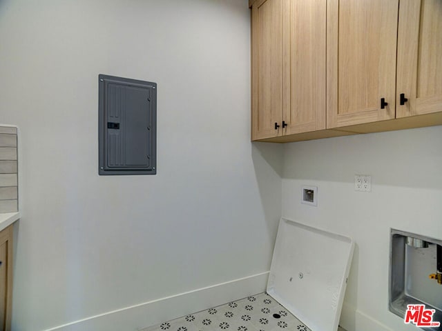 laundry area with washer hookup, light tile floors, and cabinets