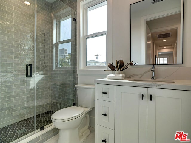 bathroom with walk in shower, toilet, a healthy amount of sunlight, and vanity