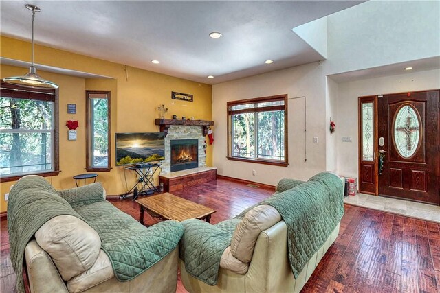 living room featuring dark tile flooring and a stone fireplace