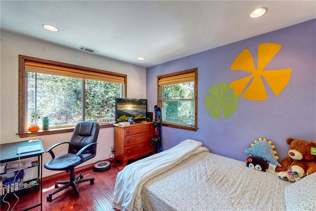 bedroom with dark hardwood / wood-style floors and multiple windows