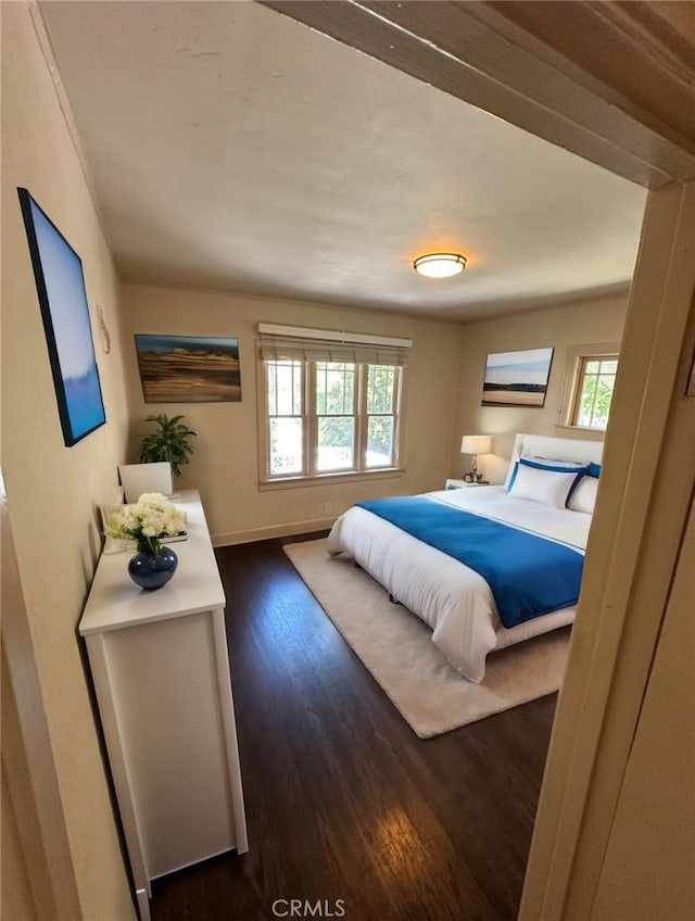 bedroom featuring dark hardwood / wood-style flooring and multiple windows