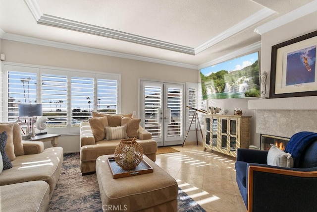 interior space featuring a raised ceiling, ornamental molding, light tile patterned floors, and french doors