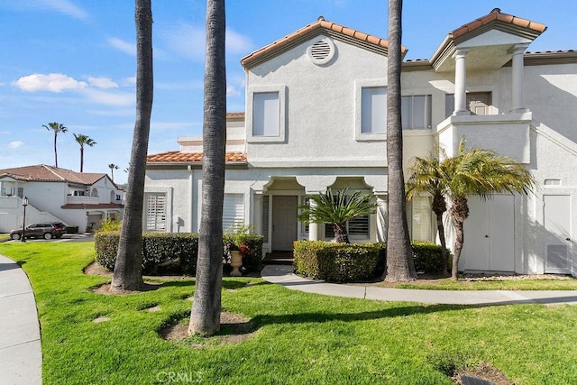 mediterranean / spanish house featuring a front lawn