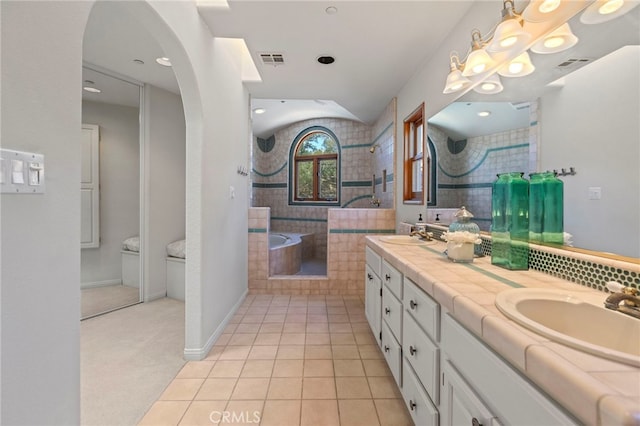 bathroom featuring tile patterned floors, independent shower and bath, and vanity