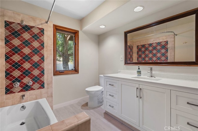 full bathroom featuring tiled shower / bath, vanity, and toilet