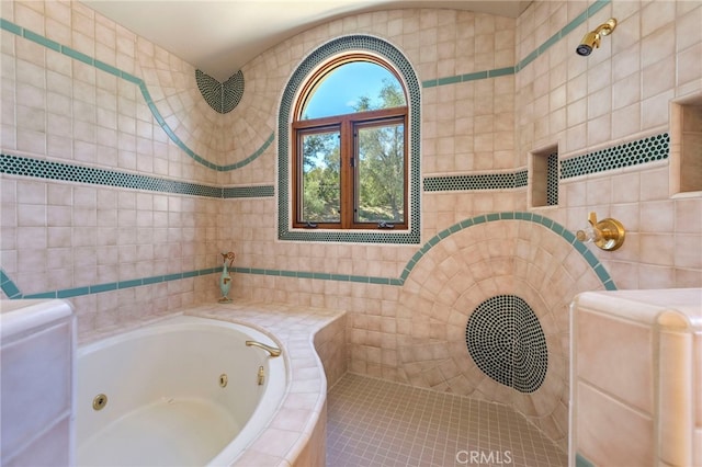 bathroom with tile patterned floors, tiled bath, and tile walls