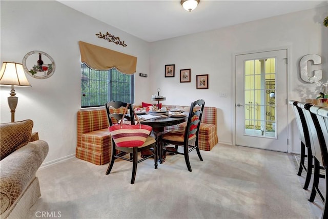 dining space featuring light carpet