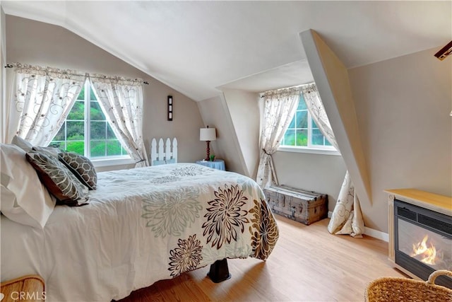 bedroom with light hardwood / wood-style floors and vaulted ceiling