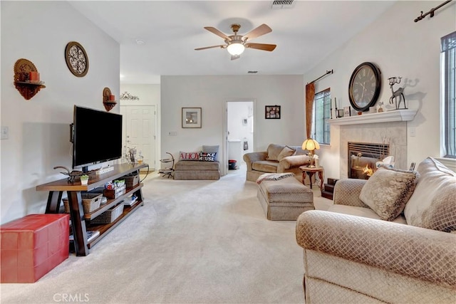 carpeted living room featuring ceiling fan and a fireplace