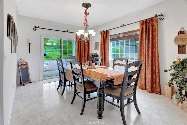 dining room with light tile patterned floors and an inviting chandelier