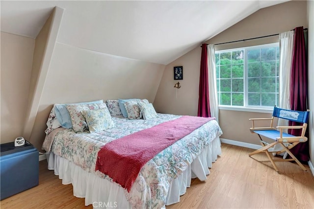 bedroom with hardwood / wood-style floors and lofted ceiling