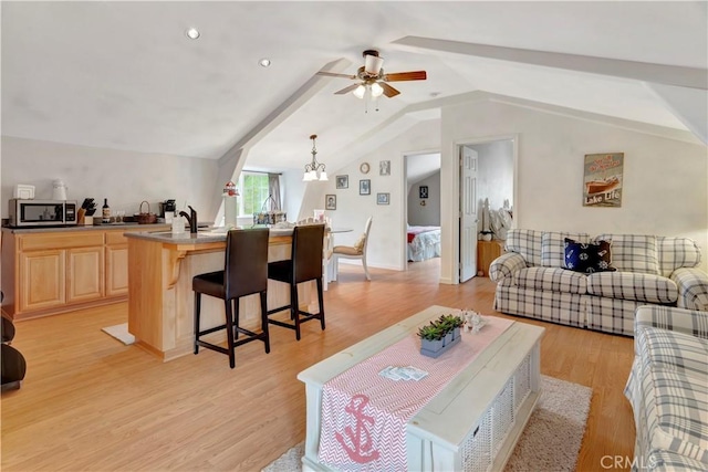 living room featuring light hardwood / wood-style flooring, lofted ceiling with beams, and ceiling fan with notable chandelier