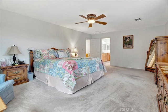 bedroom with light colored carpet, ceiling fan, and ensuite bathroom