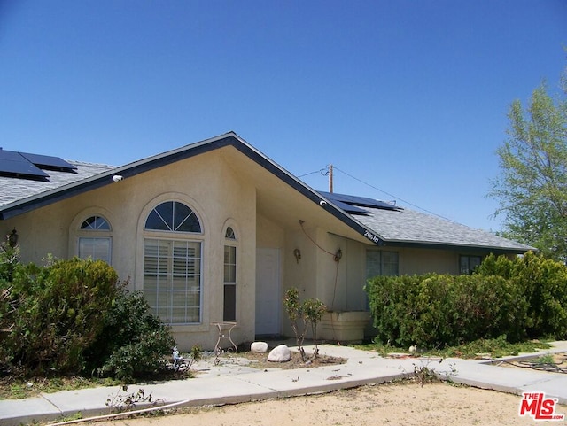 ranch-style home featuring solar panels