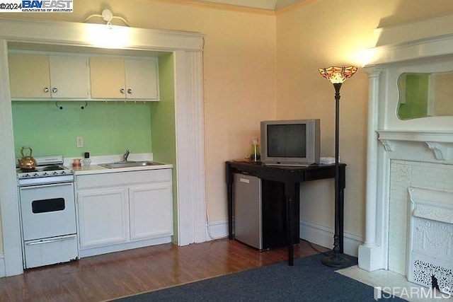 kitchen featuring white cabinets, white range oven, dark wood-type flooring, and sink