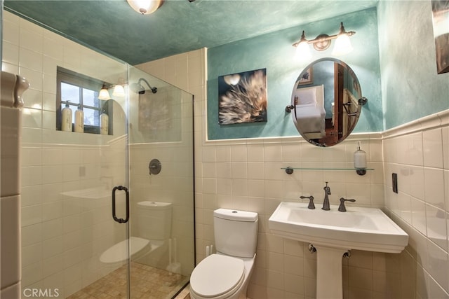 bathroom with a shower with door, tasteful backsplash, and tile walls