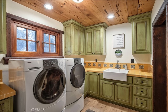 laundry area featuring sink, cabinets, wood ceiling, light hardwood / wood-style flooring, and washer and dryer