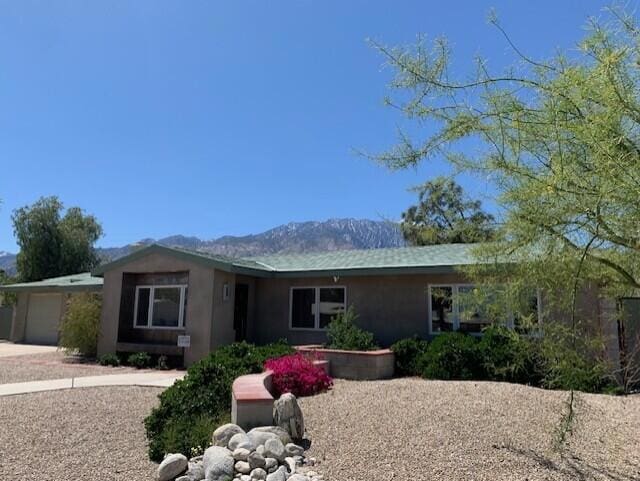 back of house with a mountain view and a garage