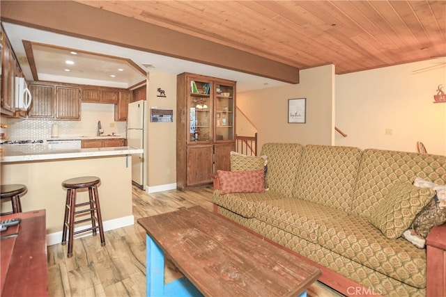 living room featuring light hardwood / wood-style flooring, sink, and wood ceiling