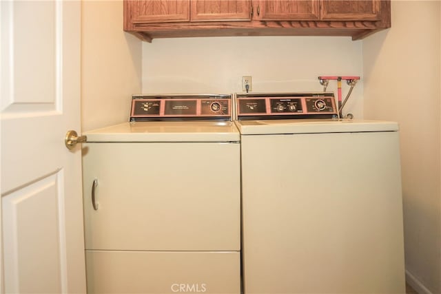 washroom with cabinets and washer and dryer