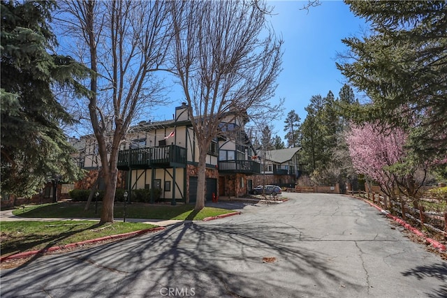 view of front of home with a balcony and a front lawn