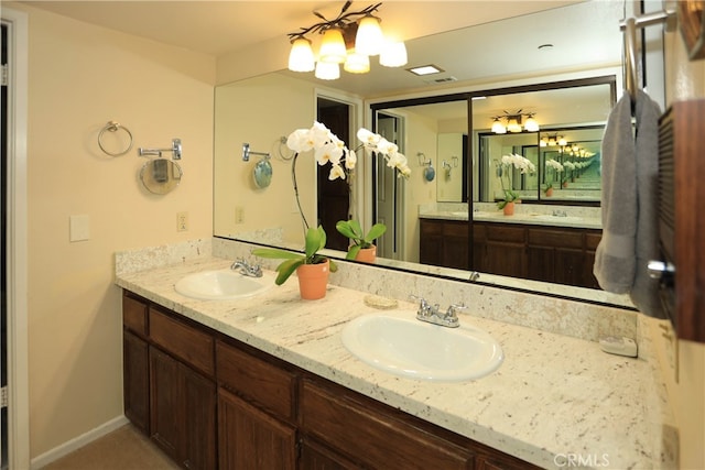 bathroom with vanity and a chandelier