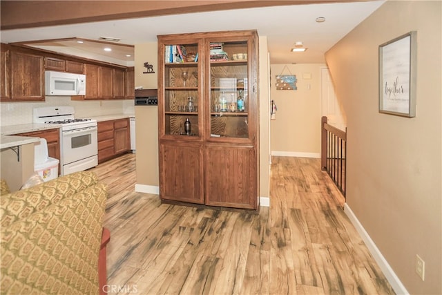 kitchen with light hardwood / wood-style floors and white appliances