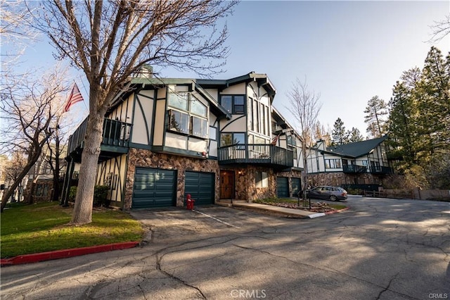 39802 Lakeview Dr Unit 12, Big Bear Lake, CA 92315 - tudor house with stone siding, driveway, an attached garage, and stucco siding