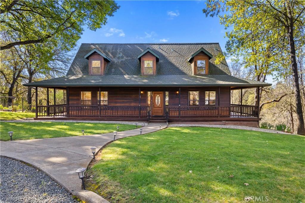 country-style home featuring a front yard and covered porch