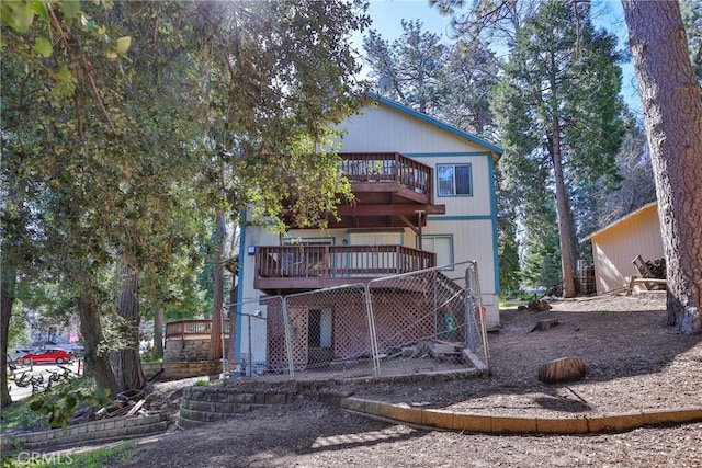 rear view of property featuring a wooden deck