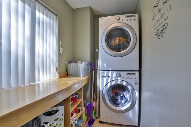 washroom featuring stacked washer and dryer and light hardwood / wood-style floors