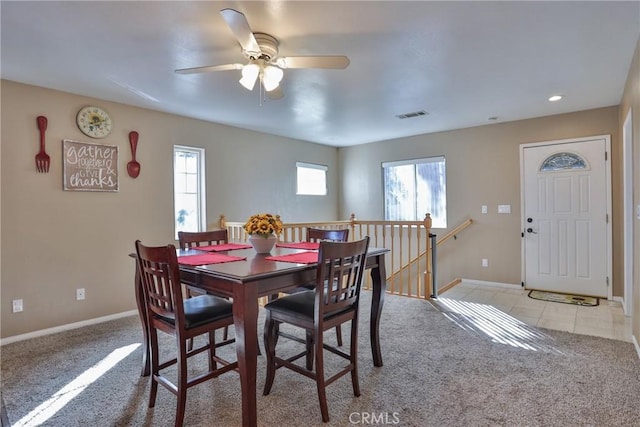 dining area featuring ceiling fan, a healthy amount of sunlight, and light carpet