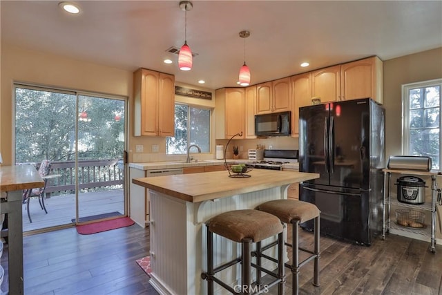 kitchen with a center island, plenty of natural light, dark wood-type flooring, and black appliances