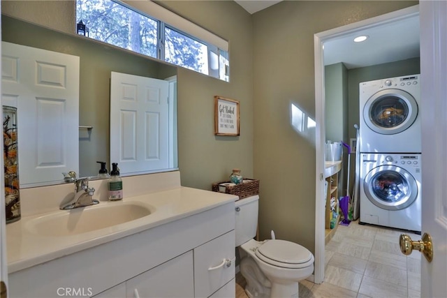 bathroom featuring vanity, toilet, and stacked washer and dryer