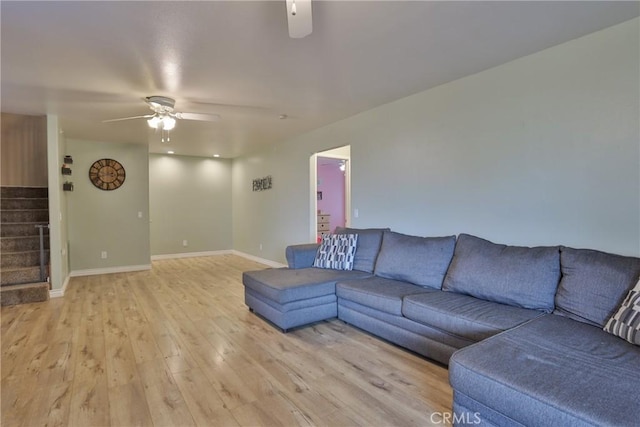 living room with light hardwood / wood-style flooring and ceiling fan