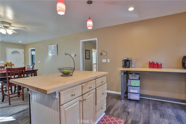 kitchen featuring wood counters, ceiling fan, decorative light fixtures, a kitchen island, and dark hardwood / wood-style flooring