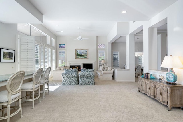 carpeted living room with ceiling fan