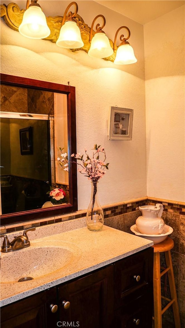 bathroom with vanity and tile walls