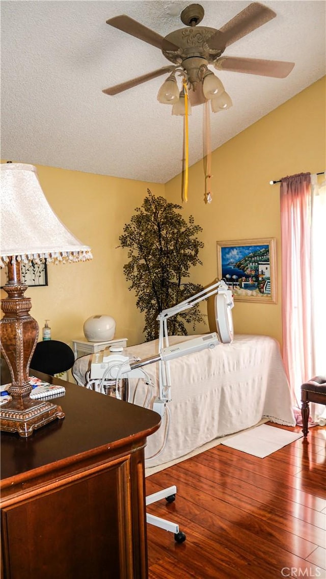 office area with hardwood / wood-style floors, a textured ceiling, ceiling fan, and lofted ceiling