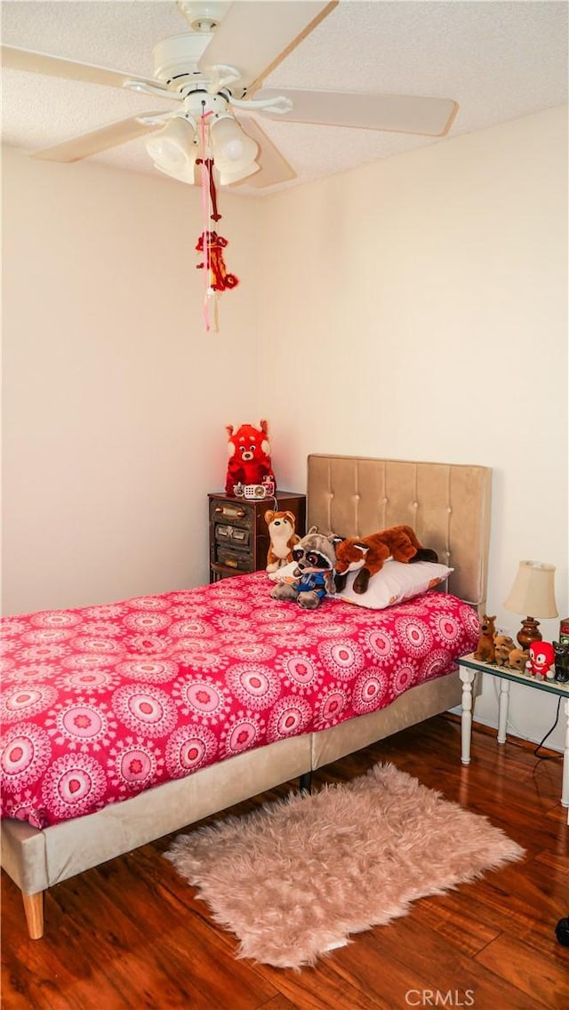 bedroom featuring wood-type flooring, a textured ceiling, and ceiling fan