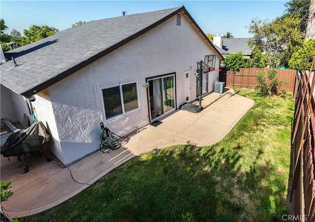 rear view of house with a patio, central air condition unit, and a lawn