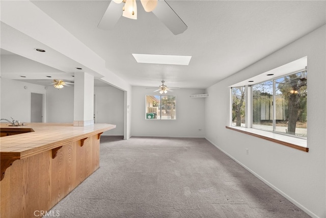 interior space featuring sink, ceiling fan, and a skylight