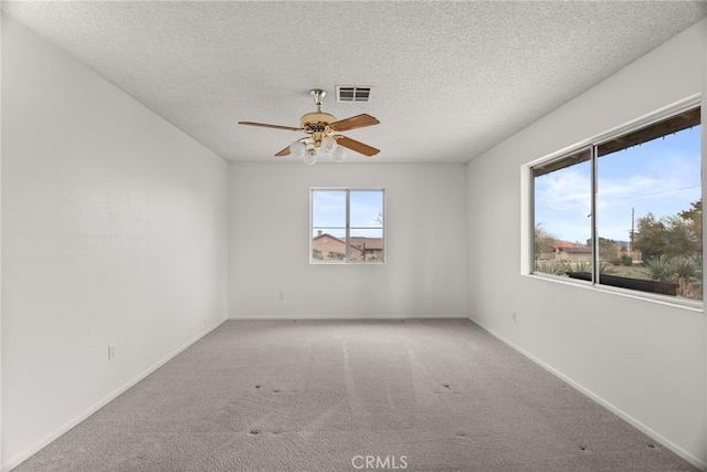 carpeted empty room featuring ceiling fan and a textured ceiling