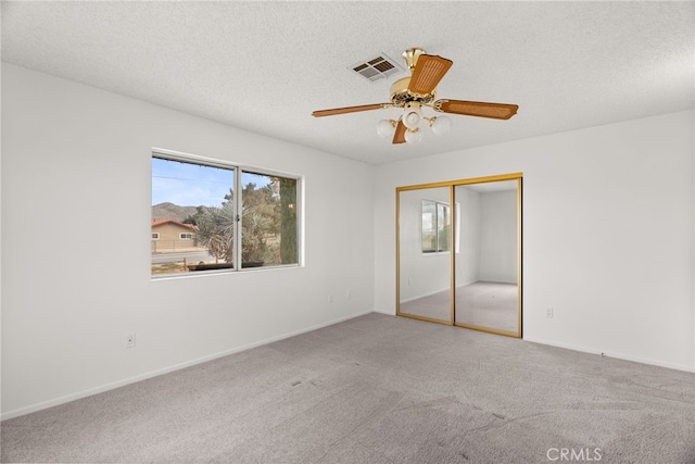 spare room with ceiling fan, carpet flooring, and a textured ceiling