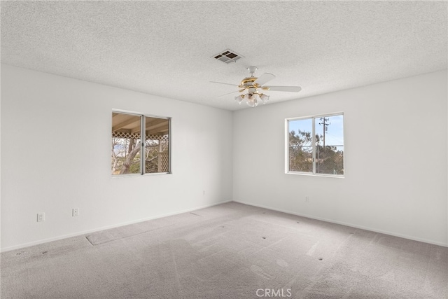 carpeted empty room featuring a textured ceiling and ceiling fan