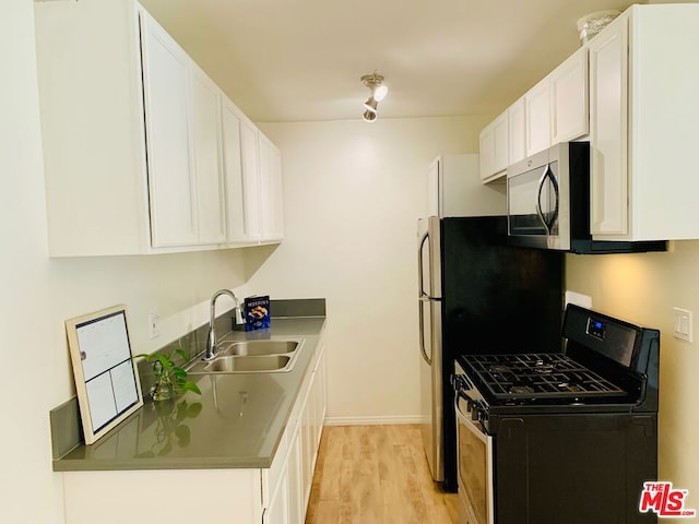 kitchen featuring light hardwood / wood-style flooring, white cabinetry, sink, and black gas range