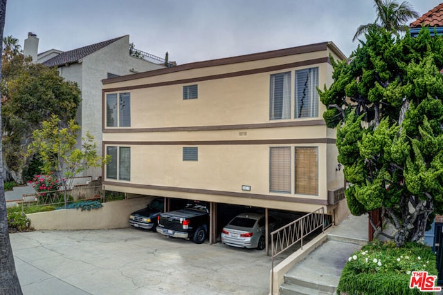 back of house featuring a carport