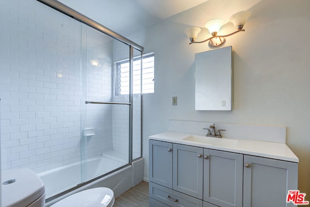 full bathroom with shower / bath combination with glass door, vanity, and toilet