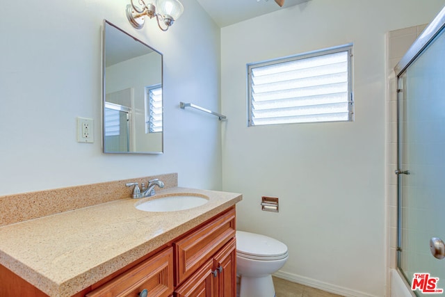 bathroom featuring a healthy amount of sunlight, vanity, toilet, and tile patterned floors